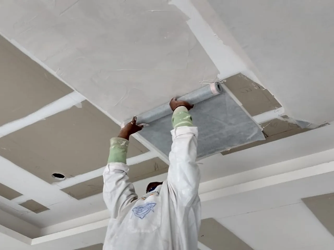Instalador adhiriendo el film radiante al plafón durante la obra